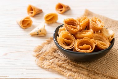 Çıtır hindistan cevizi rulosu (Asya atıştırması) masada.