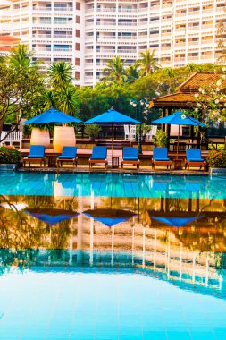 Otelde ve tatil beldesinde yüzme havuzunda güzel şemsiye ve sandalye - tatil ve tatil konseri