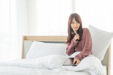 Yatakta tabletle çalışan güzel Asyalı kadınlar