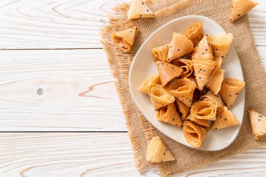 Çıtır hindistan cevizi rulosu (Asya atıştırması) masada.