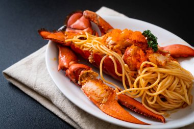 Beyaz tabakta karides yumurtalı ıstakoz spagettisi.