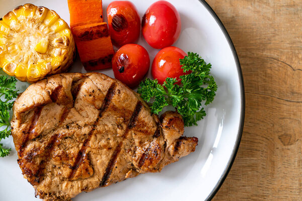 grilled and barbecue fillet pork steak with corn, carrot and tomatoes