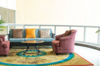 Boş kanepe ve yastıklı sandalye bir odada.