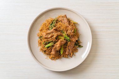 Kızarmış pirinç vermicelli şehriyeli, siyah soya soslu ve domuz etli, Asya usulü.