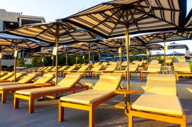 Otel tatil beldesinde yüzme havuzunda şemsiyeli yatak havuzu.