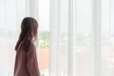 Güzel Asyalı kadınlar sabah perdeyi açar.