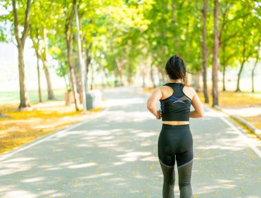 Parkta koşan Asyalı kadın.