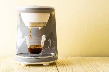 Kahve makinesi ahşap arka planda kahve yapıyor.