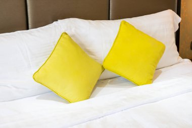 Otel odasındaki yatakta rahat yastık süslemesi