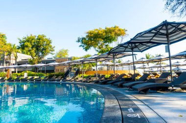 Seyahat ve tatil konsepti için otel tatil beldesinde yüzme havuzunda şemsiyesi ve sandalyesi olan güzel tropik plaj ve deniz.