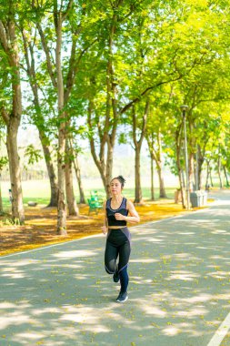 Parkta koşan Asyalı kadın.