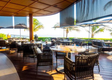 Seyahat ve tatil konsepti için okyanus sahili arka planına sahip bahçe terası ve sandalye.