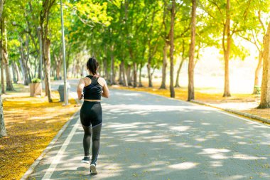 Parkta koşan Asyalı kadın.