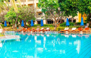 Otelde ve tatil beldesinde yüzme havuzunda güzel şemsiye ve sandalye - tatil ve tatil konseri