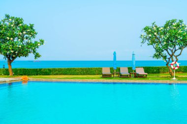 Havuz kenarındaki havuz, havuz, şemsiye, deniz manzaralı havuz tatilleri ve tatil konsepti.