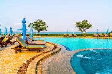 Havuz kenarındaki havuz, havuz, şemsiye, deniz manzaralı havuz tatilleri ve tatil konsepti.