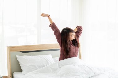 Güzel Asyalı kadınlar yatakta ve sabah uyanırlar.