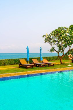 Havuz kenarındaki havuz, havuz, şemsiye, deniz manzaralı havuz tatilleri ve tatil konsepti.