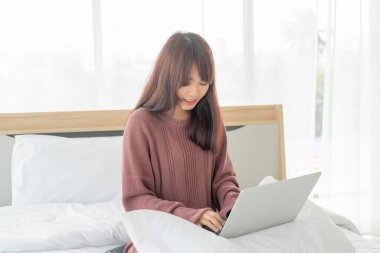 Evde dizüstü bilgisayarla çalışan Asyalı kadınlar.