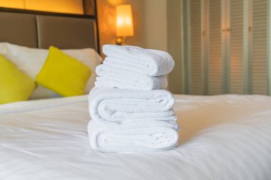 Otel odasında beyaz havlu katlanır.