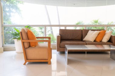 Boş kanepe ve yastıklı sandalye bir odada.