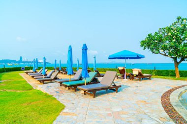 Havuz kenarındaki havuz, havuz, şemsiye, deniz manzaralı havuz tatilleri ve tatil konsepti.