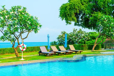 Havuz kenarındaki havuz, havuz, şemsiye, deniz manzaralı havuz tatilleri ve tatil konsepti.