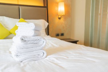 Otel odasında beyaz havlu katlanır.