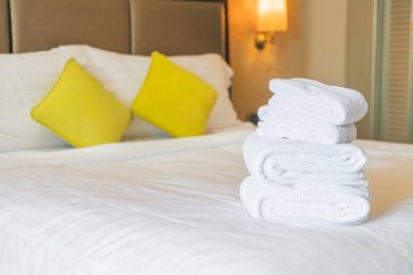 Otel odasında beyaz havlu katlanır.