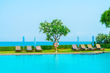 Havuz kenarındaki havuz, havuz, şemsiye, deniz manzaralı havuz tatilleri ve tatil konsepti.