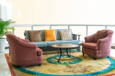 Boş kanepe ve yastıklı sandalye bir odada.