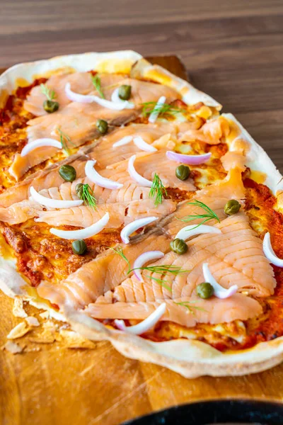 smoked salmon pizza on wood board - Italian food style