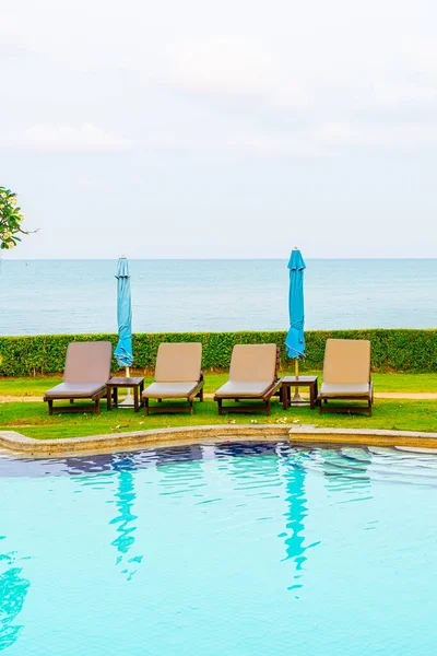 Sandalye havuzu ya da yüzme havuzu etrafında şemsiye olan yatak havuzu