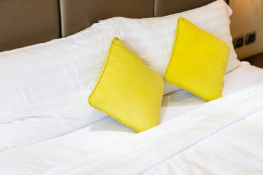 Otel odasındaki yatakta rahat yastık süslemesi
