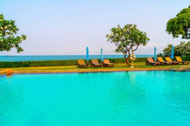 Havuz kenarındaki havuz, havuz, şemsiye, deniz manzaralı havuz tatilleri ve tatil konsepti.