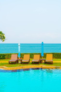 Havuz kenarındaki havuz, havuz, şemsiye, deniz manzaralı havuz tatilleri ve tatil konsepti.