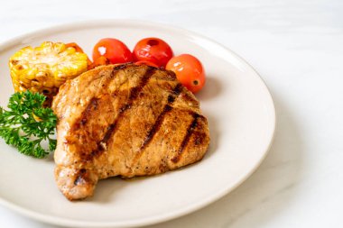 Izgara ve ızgara fileto domuz bifteği, mısır, havuç ve domates.