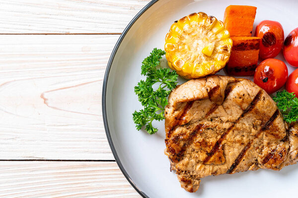 grilled and barbecue fillet pork steak with corn, carrot and tomatoes