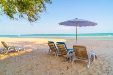 Okyanus geçmişi olan kumsalda boş bir plaj sandalyesi.