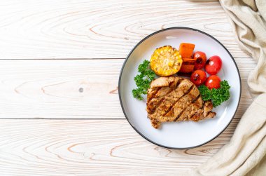 Izgara ve ızgara fileto domuz bifteği, mısır, havuç ve domates.