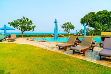 Havuz kenarındaki havuz, havuz, şemsiye, deniz manzaralı havuz tatilleri ve tatil konsepti.