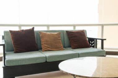 Boş kanepe ve yastıklı sandalye bir odada.