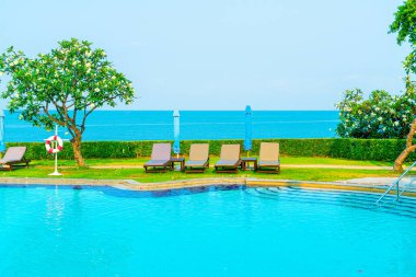 Havuz kenarındaki havuz, havuz, şemsiye, deniz manzaralı havuz tatilleri ve tatil konsepti.