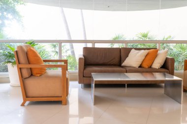 Boş kanepe ve yastıklı sandalye bir odada.