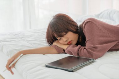 Yatakta tabletle çalışan güzel Asyalı kadınlar