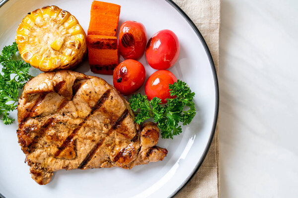 grilled and barbecue fillet pork steak with corn, carrot and tomatoes