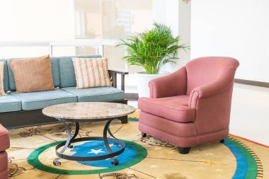 Boş kanepe ve yastıklı sandalye bir odada.