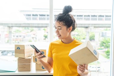 İş yerinde paketleme kutusuyla çalışan Asyalı Kadın işyeri sahibi - çevrimiçi alışveriş KOBİ girişimcisi veya serbest çalışma konsepti