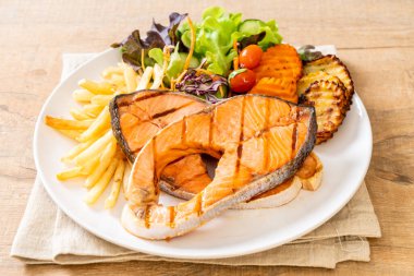 Çift ızgara somon bifteği, sebze ve patates kızartması.