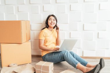 Genç Asyalı iş adamları online satış başlatırken e-posta veya web sitesinden müşteri siparişlerini kontrol etmek ve paketleri hazırlamak için bilgisayar kullanır - çevrimiçi alışveriş veya çevrimiçi konsept satmak